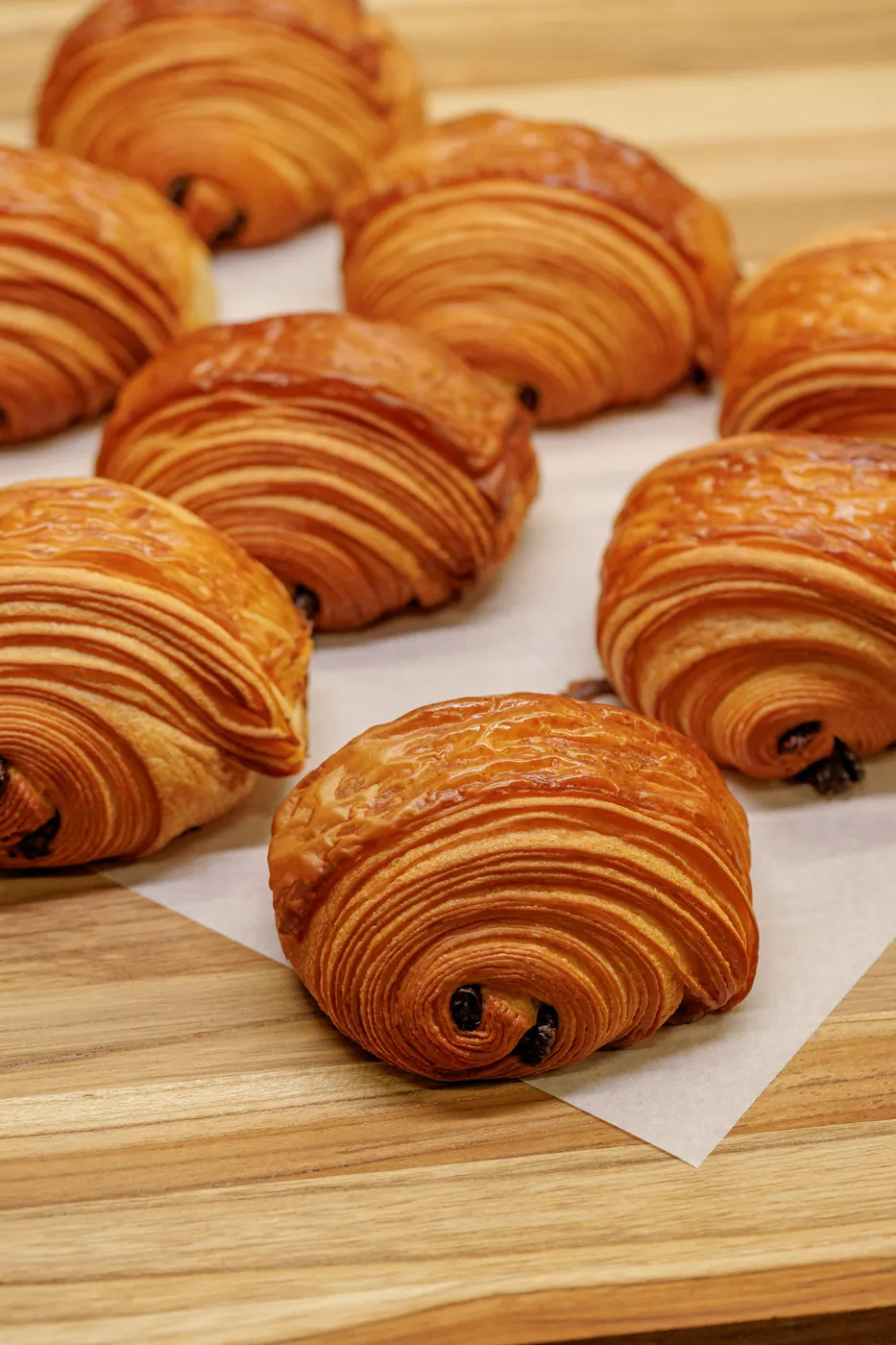 Croissants folhados dourados sobre uma tábua de madeira
