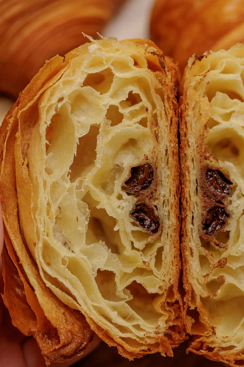 Croissant cortado ao meio mostrando o miolo alveolado em favo de mel